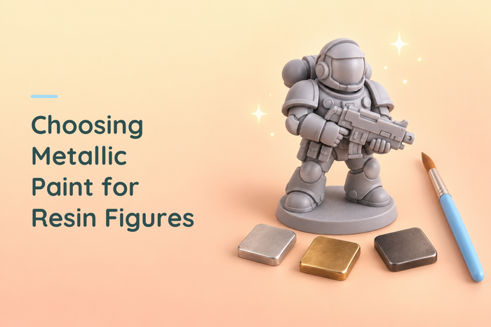 Unpainted armoured resin figure beside metallic paint samples and a blue brush