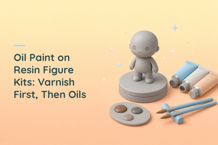 Cozy illustrated grey resin figurine on a turntable beside three oil paint tubes, a palette of earth tones and two brushes
