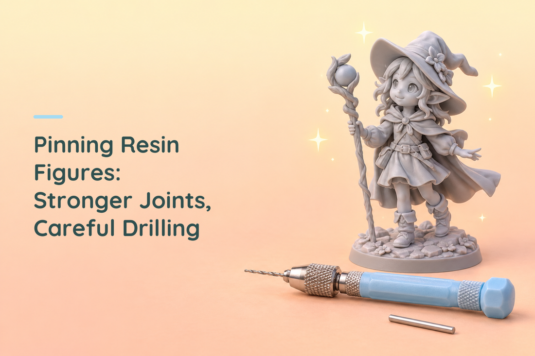 Grey resin witch figure beside a blue hand pin vise and short metal rod