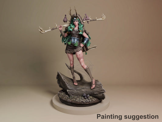 Artemis resin figure from Hades, painted in green and brown, posed dynamically with dual staffs on a sculpted base, front three-quarter view.
