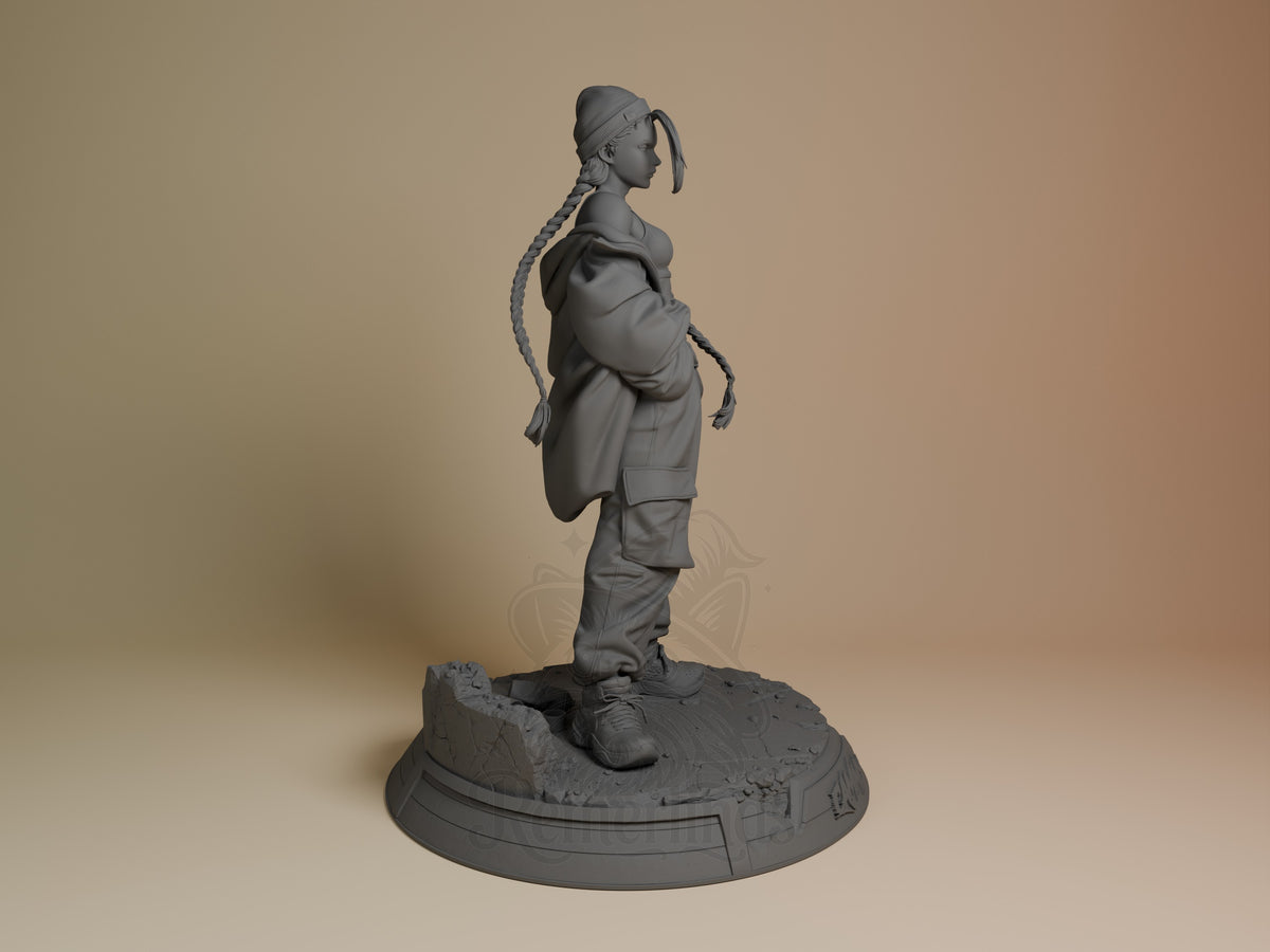 Cammy resin figure shown in right profile view, unpainted gray, standing on textured base with braided hair detail and tactical outfit visible.