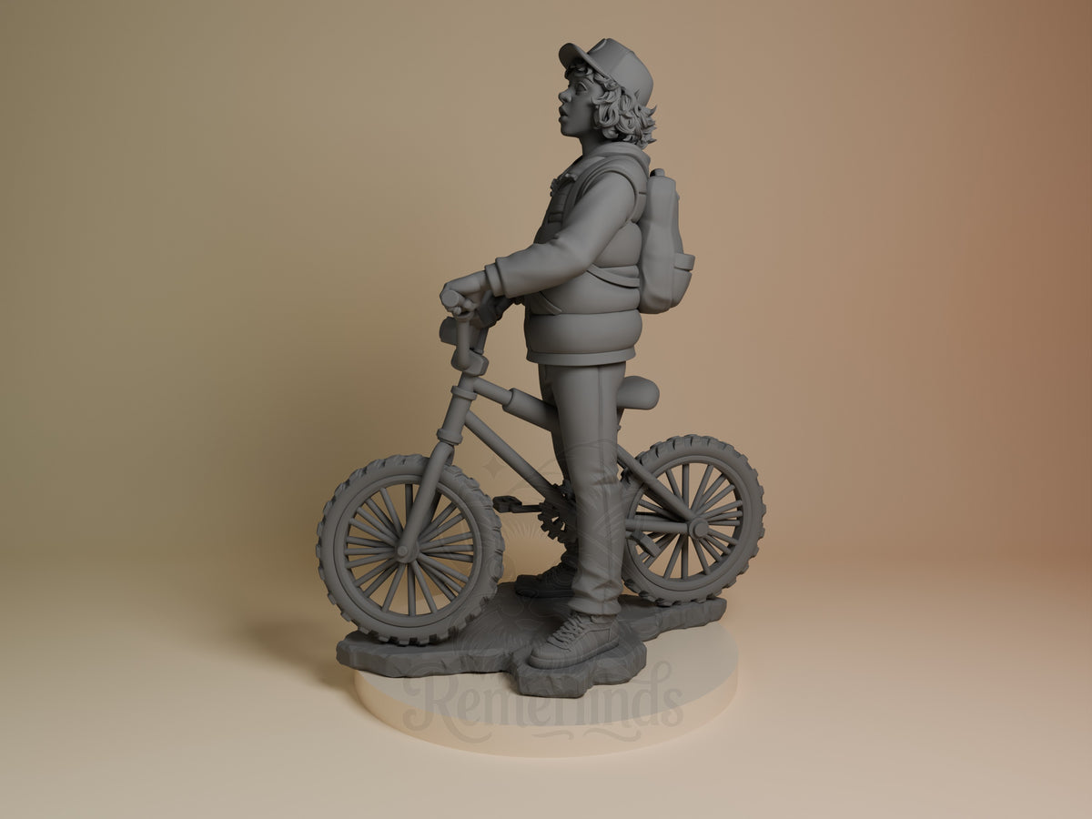 Dustin from Stranger Things is shown side-on with a bicycle and sculpted base as an unpainted resin figure.