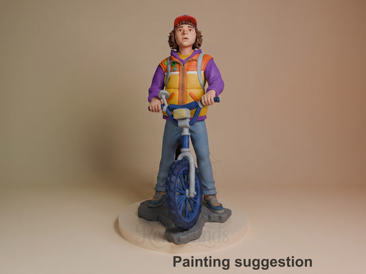 Dustin from Stranger Things 3D resin figure standing with bike, wearing red cap, purple hoodie, and orange vest, fully painted on round base.