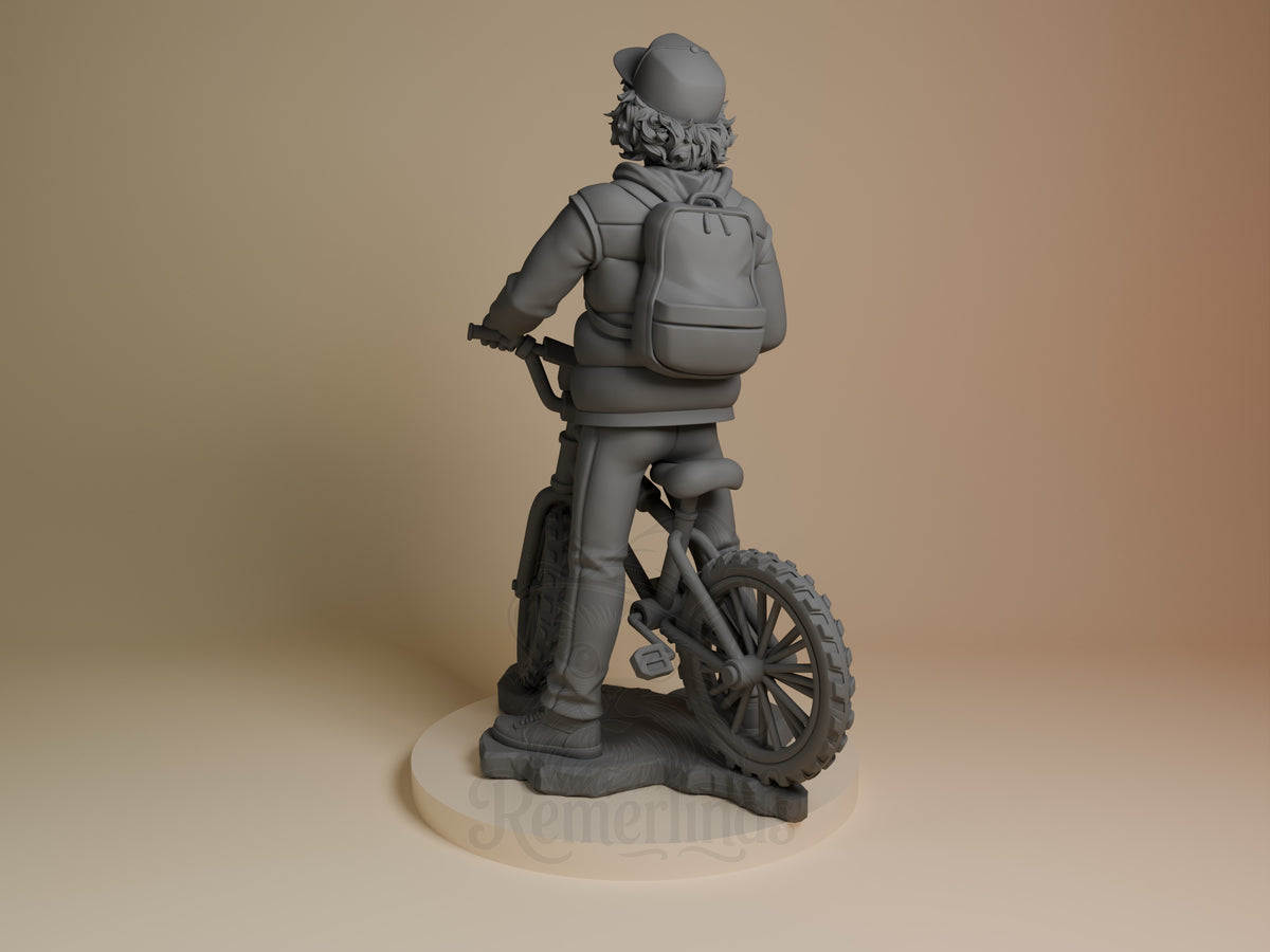 Rear view shows unpainted Dustin from Stranger Things as a resin figure with backpack, bicycle, and sculpted base.
