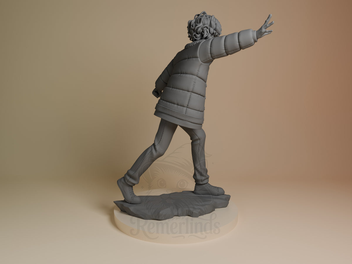 The unpainted resin figure of Eleven from Stranger Things is shown from behind with arms extended on a sculpted base.