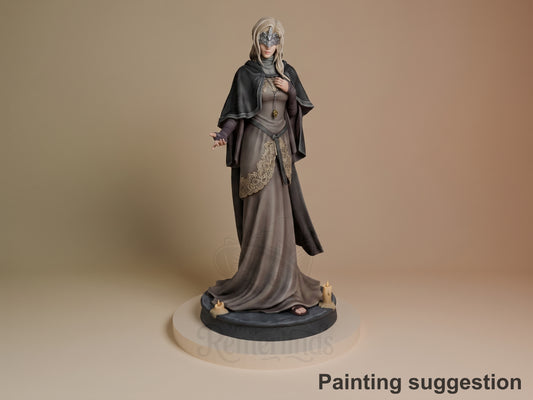 Fire Keeper resin figure from Dark Souls, painted in grays and blacks, standing on dark base with candles, wearing ornate robes and mask, black cape draped over shoulders.