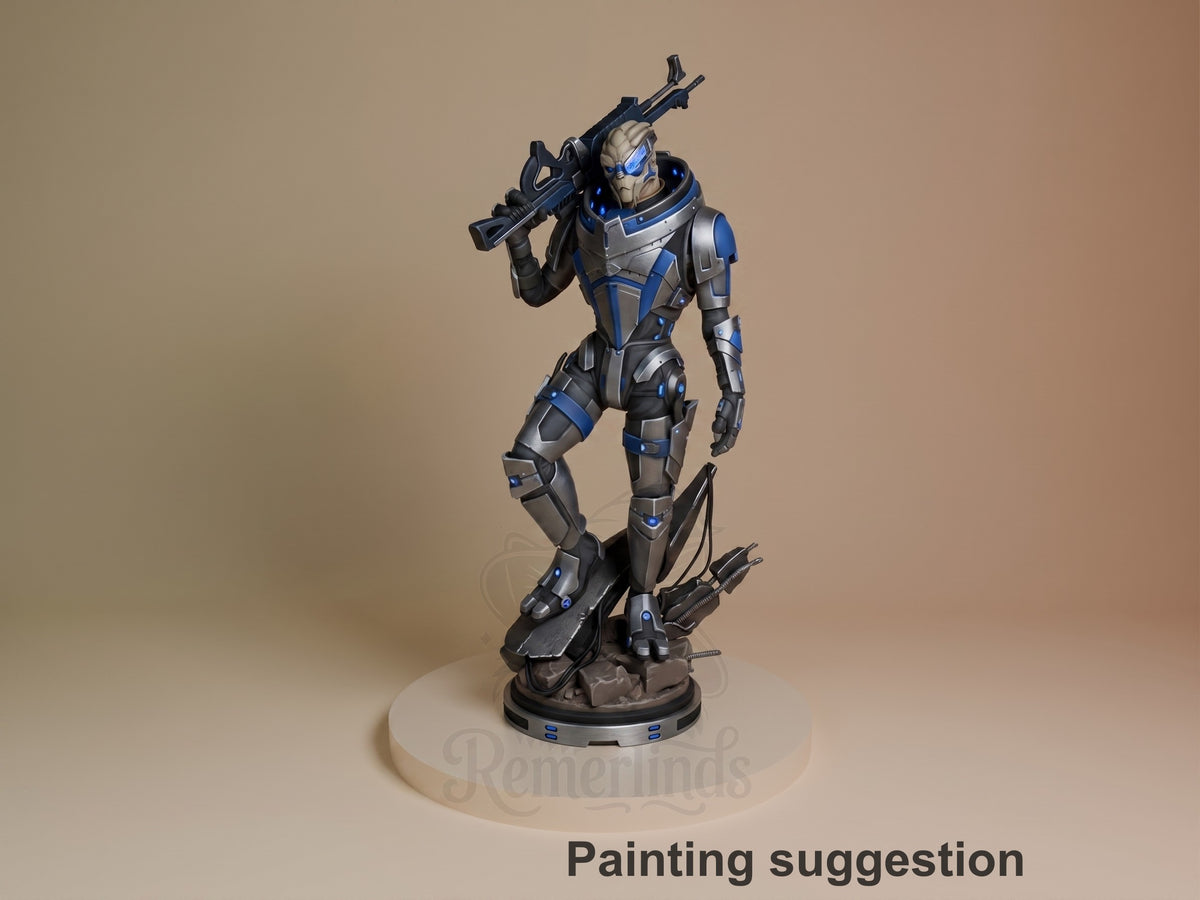 Garrus resin figure painted in blue and gray armor, holding rifle over shoulder, standing on rocky base against tan background.