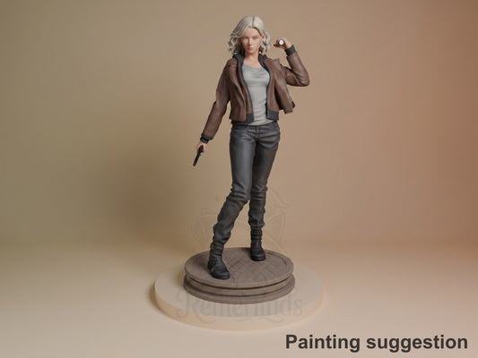Grace from Resident Evil resin figure in painted brown jacket and black pants, standing on circular base with hand raised, against neutral background.
