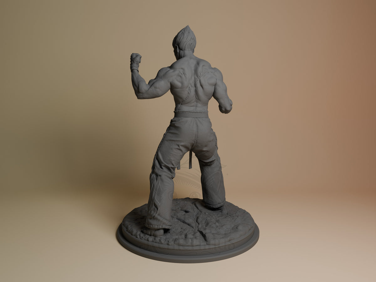Kazuya resin figure shown from behind in fighting stance, unpainted gray resin, textured rocky base, left profile view.