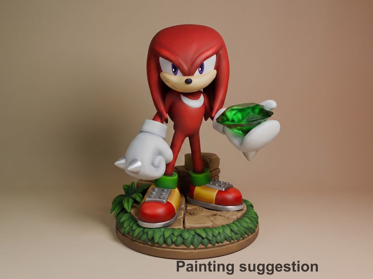 Knuckles resin figure painted in red and white, standing on grass base holding emerald, white gloves visible, detailed shoes and neutral backdrop.