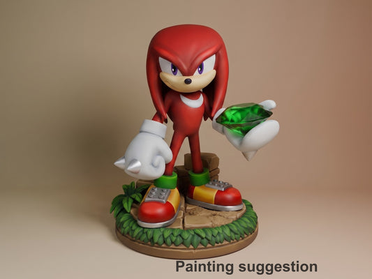 Knuckles resin figure painted in red and white, standing on grass base holding emerald, white gloves visible, detailed shoes and neutral backdrop.