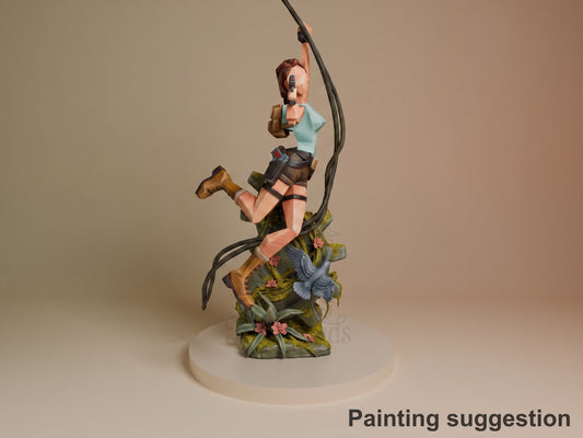 Lara Croft resin figure from Tomb Raider in dynamic climbing pose on moss-covered base, detailed paint work on clothing and skin tones, grappling rope accessory.