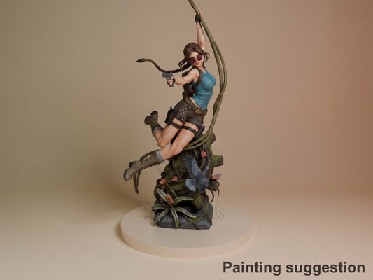 Lara Croft resin figure in dynamic climbing pose with painted details, holding rope and pistol, on decorative base with flora.