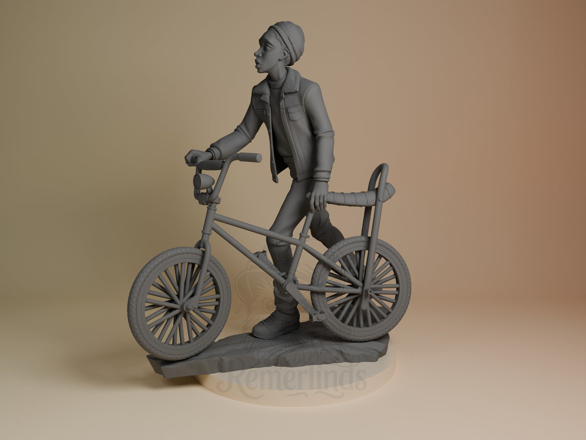 Lucas from Stranger Things is an unpainted gray resin figure at an angle with bicycle on a sculpted base.