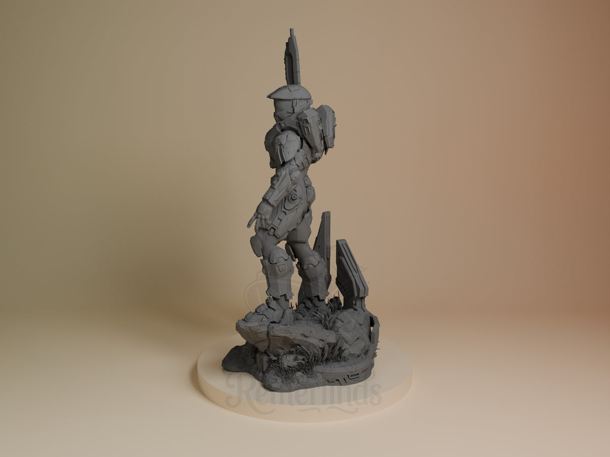 Master Chief resin figure in grey primer, standing on rocky base with weapon raised, shown from angled side view.