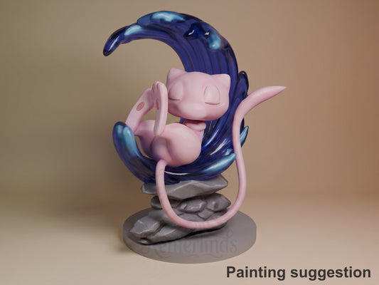 Mew resin figure painted in pink and deep blue, seated on rocky base with tail curved upward, eyes closed in peaceful pose.