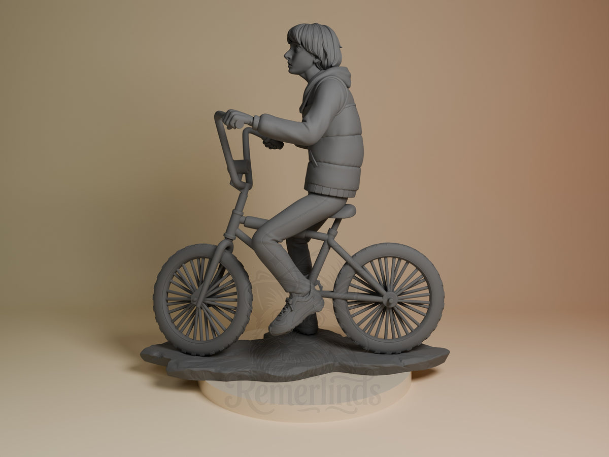 Mike from Stranger Things is an unpainted resin figure riding a bicycle on a sculpted base.
