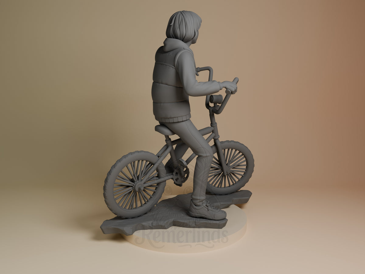 Rear view of Mike from Stranger Things, an unpainted resin figure on a bicycle and sculpted base.