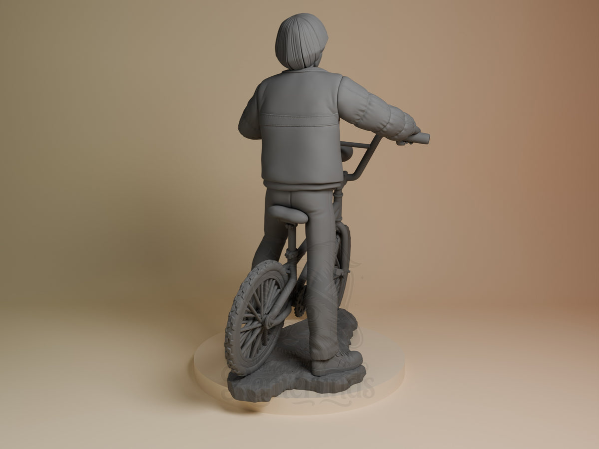 Will from Stranger Things resin figure shown from behind on circular base, unpainted gray, riding bicycle with hands on handlebars.