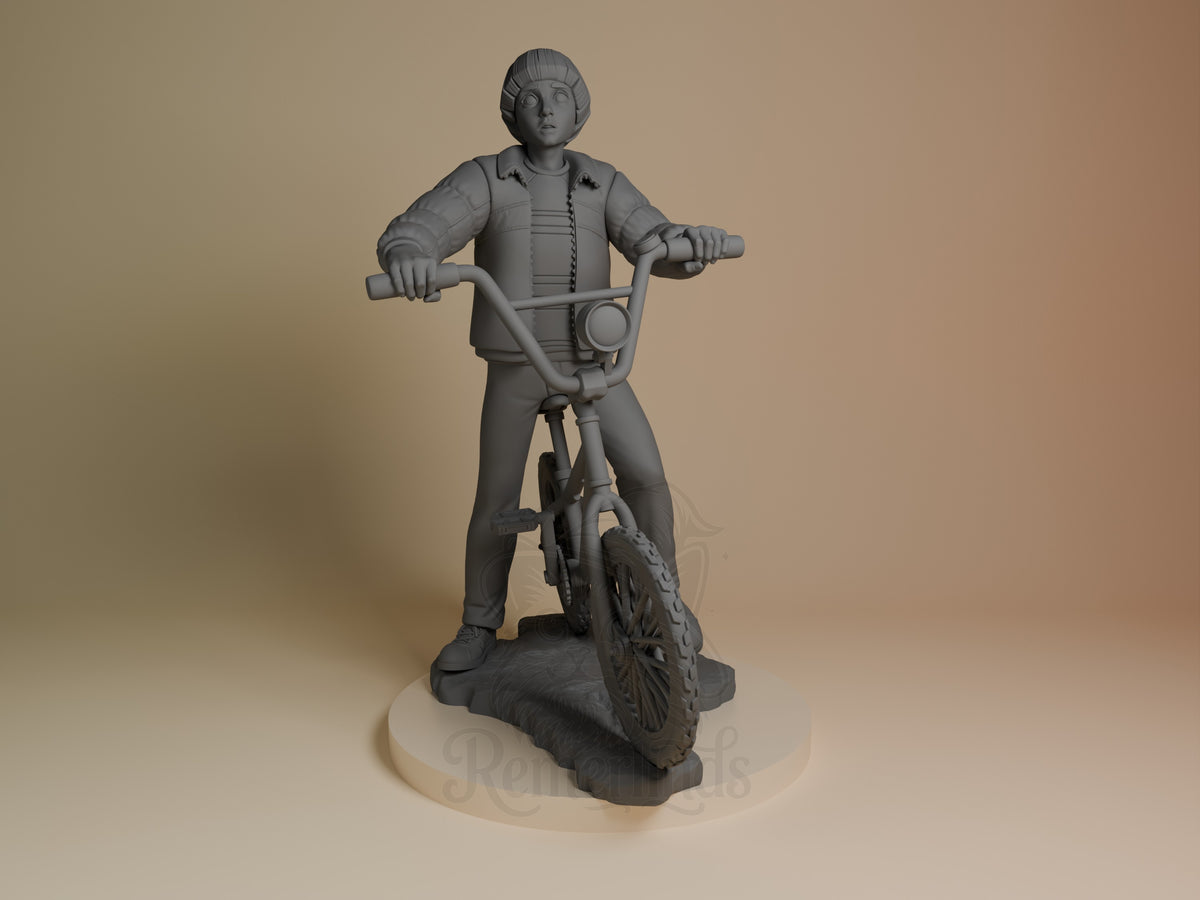 Will from Stranger Things 3D resin figure standing on bike, arms outstretched, unpainted gray finish, viewed from front on cream base.