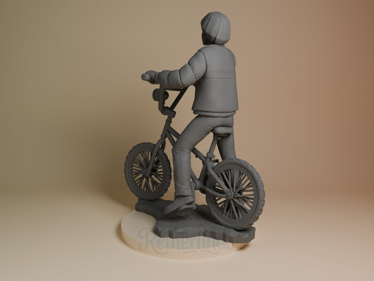 Will Byers resin figure from Stranger Things riding a bicycle, shown from behind, unpainted gray finish on cream base.