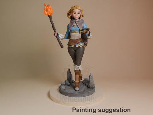 Princess Zalde resin figure from Tales of Daelz, painted in blue and gold robes, holding a flaming staff and gun, standing on rocky base.